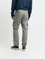 Pantalon cargo de corte ajustado en color verde grisáceo, con bolsillos laterales con solapa y puños elásticos en los tobillos.