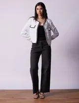 Chaqueta de tweed negra marca Nanette, con escote a la base, abertura central con botones, bolsillos delanteros, aplique de botones perlados en los puños, ribete en contraste blanco y forro interno.