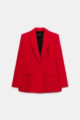 Blazer entallada de color rojo con cuello solapa, manga larga y hombreras. Presenta bolsillos con solapa en el delantero, forro interior negro a contraste y cierre frontal con botones forrados del mismo tono.