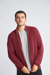 Campera tejida de algodón con cierre frontal completo, cuello alto y mangas largas con puños acanalados. Presenta un diseño de punto acanalado vertical y un pequeño logo bordado en el ruedo.