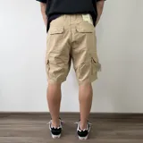 Bermuda cargo de gabardina color gris oscuro, con múltiples bolsillos laterales con solapa y cierre de botones.