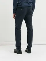 Pantalon de corte clasico confeccionado en algodon sarga con elastano, color marron. Presenta bolsillos delanteros inclinados y bolsillos traseros de ribete con boton.