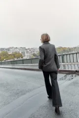 Blazer de corte sastrero confeccionado en tejido de lana con diseño de espiga. Presenta cuello con solapas, hombreras, cierre frontal con un botón y bolsillos delanteros con solapa.