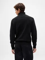Buzo de punto con cuello alto tipo polera, de manga larga y diseño clásico con puños y ruedo acanalados.