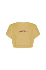Remera corta color amarillo con estampado frontal con la frase "I like to make boys cry" y corazones rojos.