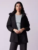Campera impermeable color gris claro, marca Gallery. Tiene abertura central con cierre oculto y botones a presión, bolsillos delanteros y capucha plegable en el cuello.