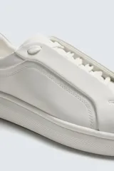 Zapatilla negra de cordones, con parte superior lisa y cordonera oculta. Posee suela con volumen a tono.