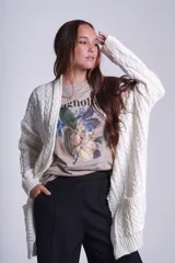 Cárdigan negro tejido con diseño de ochos, corte holgado y bolsillos frontales.