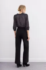 Pantalón recto negro de tiro alto con cierre trasero invisible y bolsillos laterales.