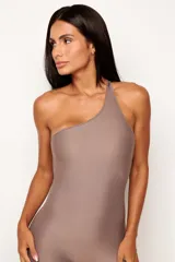 Jumpsuit deportivo de una sola pieza, con diseño asimétrico de un solo hombro y espalda descubierta. Confeccionado en tejido de poliamida con acabado mate, ofrece un ajuste ceñido y elástico ideal para actividades físicas o looks urbanos.