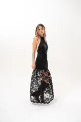 Vestido largo negro de encaje con cuello halter y espalda descubierta, con forro corto y falda translúcida.