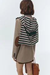 Blazer de lana color beige, con solapas de cuello sastre, cierre frontal de dos botones y bolsillos rectangulares. Presenta un calce relajado tipo overfit y hombreras marcadas.