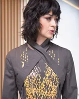 Blazer gris con estampado artesanal amarillo, de corte recto con aberturas en la espalda y cuello lazo.