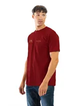 Remera de manga corta color bordó, con cuello redondo y un pequeño estampado dorado en el pecho.