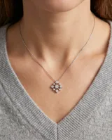 Collar de plata 925 con cadena fina y dije geométrico en forma de flor o estrella, engastado con pequeñas circonias brillantes.