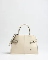 Cartera tipo bolso de mano color beige, confeccionada en símil cuero, con doble asa corta y detalles de tiras laterales decorativas con hebillas. Incluye correa ajustable y el logotipo de la marca impreso en metal en la parte inferior frontal.