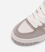 Championes de caña corta marca Satinato, confeccionados en material sintético tipo cuero (PU). Presentan un diseño de paneles en tonos beige y tostado, con suela de plataforma tipo caja y cierre mediante cordones.