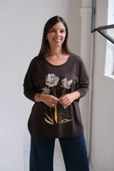 Remera de algodón color chocolate con cuello redondo, mangas largas y estampa frontal de flores en tonos plateado y dorado.