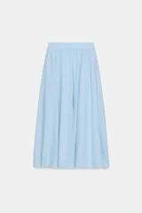 Falda midi de corte en A, color blanco, confeccionada en algodón con cintura elástica de tiro alto y forro interior a tono.