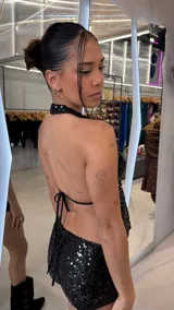 Top de lentejuelas color negro, con escote halter y espalda descubierta.