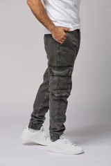 Pantalón jean gris oscuro de corte jogger con bolsillos cargo laterales y puños elásticos en los tobillos.