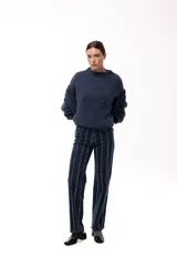 Jean de corte recto en color azul oscuro, con diseño de rayas verticales formadas por pequeños apliques brillantes a lo largo de toda la prenda.