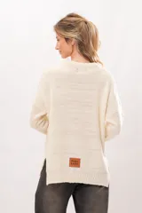 Sweater de punto color crema con cuello redondo y mangas largas.