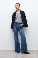 Jean de corte flare con tiro medio, confeccionado en denim azul clásico con costuras a contratono.