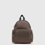 Mochila urbana marca Bubba de color marrón, confeccionada en material sintético ligero con detalles en cuero vegano. Cuenta con un compartimento principal con cierre, un bolsillo frontal amplio y dos bolsillos laterales con cierre, además de un asa superior y correas ajustables.