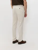 Pantalon de lino color beige, de corte recto con bolsillos delanteros y traseros con cierre de botón.