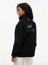 Campera de tejido polar negra Tommy Hilfiger, con cuello chimenea y cierre de cremallera. Presenta diseño Global Stripe en los laterales, bolsillos abiertos en diagonal y el logo de la marca junto con el de Cadillac Formula 1 Team en el pecho.