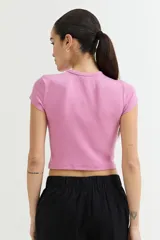 Remera crop top de manga corta, color verde claro, con textura acanalada y texto en relieve en el pecho.