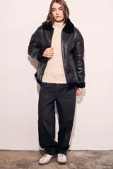 Campera gamulan negra con cuello, puños y ruedo de piel sintética.