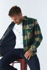 Sobrecamisa de viyela a cuadros rojos y azules con interior capitoneado, corte regular, manga larga, cierre con botones, bolsillos frontales y logo en grifa de cuero.