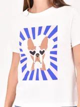 Remera lila de corte recto y mangas cortas, con estampado pequeño de un gato blanco con gorro rojo, gafas de sol y copa de vino, junto a la frase 'J'adore'.