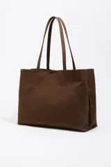 Bolso tipo shopper de Bimba y Lola, color marrón, confeccionado en gabardina con detalles en piel. Cuenta con doble asa de hombro y cierre principal con cremallera.