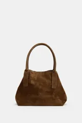 Bolso tipo shopper de piel en color marrón, con doble asa de hombro, bolsillo interior con cremallera y doble sistema de cierre con botón imantado y tira con botón metálico.