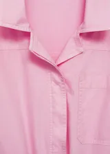 Mono largo de algodón color rosado, con cuello camisero, cierre frontal con botones, manga larga con puños vueltos y cintura elástica ajustable con cordón. Presenta bolsillos de parche en el pecho y en la parte delantera.