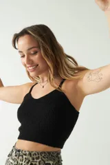 Top tejido de punto color beige, con escote corazón y breteles finos. Presenta una textura acanalada y un corte corto al cuerpo.