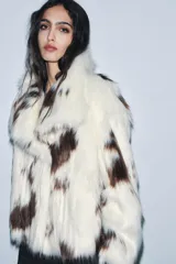 Chaqueta de pelo sintético con estampado animal tipo vaca, cuello solapa, manga larga y forro interior.