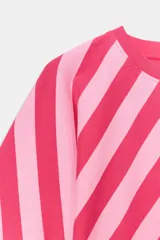 Top de algodón con estampado de rayas diagonales en tonos fucsia y rosado. Presenta cuello redondo, mangas cortas tipo murciélago y un diseño de bajo asimétrico.
