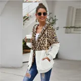Campera tipo polar con cierre frontal, diseño combinado con estampado animal print en la parte superior y tejido de peluche blanco en la parte inferior. Cuenta con capucha con cordones ajustables y dos bolsillos frontales.