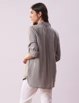 Camisa celeste de tencel con cuello con solapa, abertura central con botones ocultos, bolsillos delanteros y mangas largas regulables con presilla y botón.