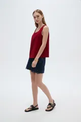 Musculosa de viscosa color beige claro, holgada, con cuello redondo y tirantes anchos formados por múltiples tiritas trenzadas.