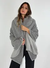 Ruana gris de lambswool con cuello y detalles bordados a mano en relieve.