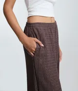 Pantalón de corte recto con textura sutil, confeccionado en tejido de poliéster con elastano. Presenta cintura media y una caída cómoda y fluida.