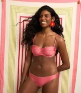 Bikini bombacha confeccionada en microfibra brillante color rosado, con detalle de pequeños adornos de madera en la cintura.