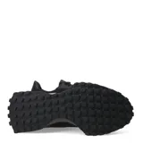 Championes urbanos New Balance modelo 327, color negro, confeccionados en una combinación de malla y material sintético. Presentan el logo 'N' característico en el lateral y una suela dentada que se extiende hacia el talón.