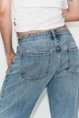 Jeans de tiro medio con corte recto, cinco bolsillos y bajo con vuelta. Cierre frontal con cremallera y botón metálico.