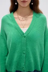 Cardigan de punto color marrón, con cuello en V profundo, cierre frontal con botones y diseño holgado de manga larga.